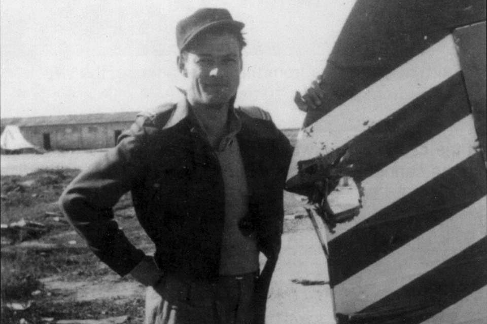 Canadian John McElroy shows off his combat-damaged rudder on January 7, 1949. (ISF/GPO)
