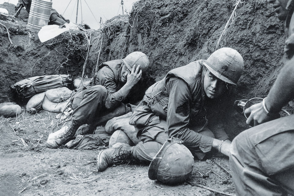 Cavalry troops at Landing Zone Wharton hunker down in a trench as enemy artillery rounds fired from Laos hit their position on April 4. (Terry Fincher/Getty Images)