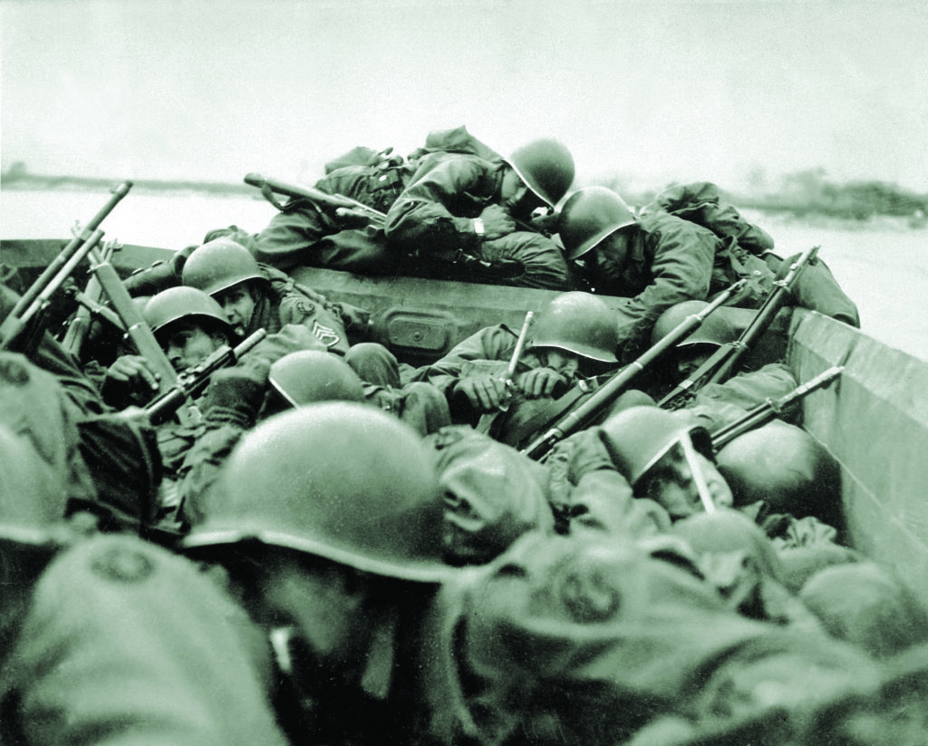 Below the aerial armada, ground troops—here, ducking from enemy fire—cross the Rhine River in assault boats. “We all tried to crawl under each other because the lead was flying around like hail,” one recalled. (National Archives)