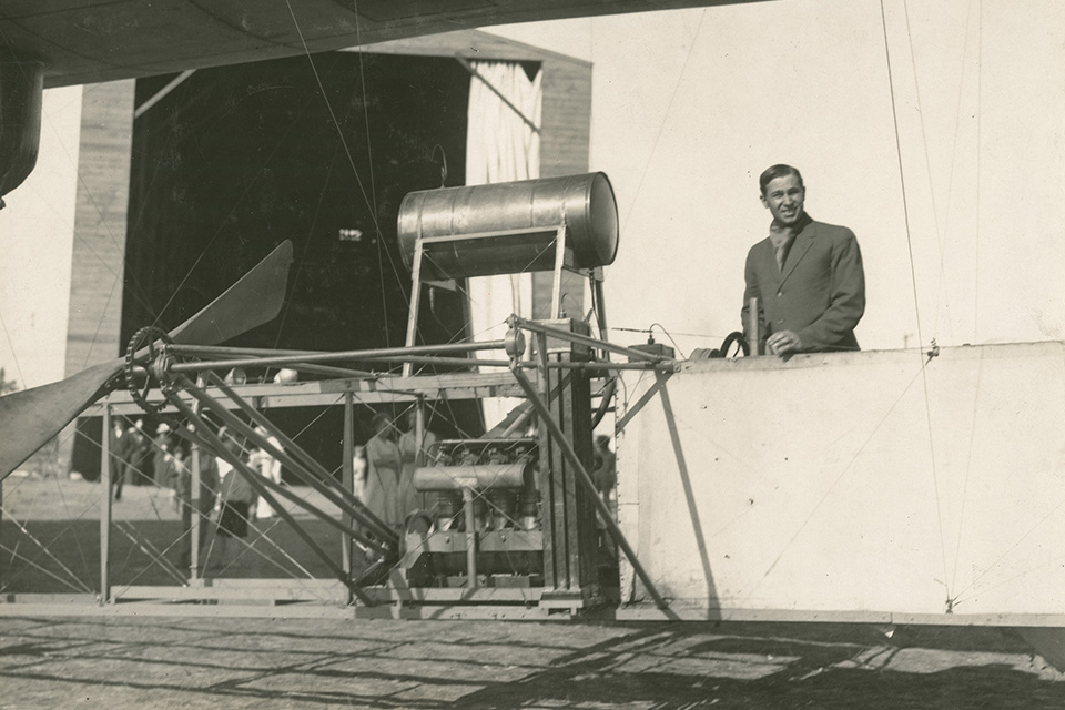 Knabenshue poses beside White City’s engine and drive system. (Wright State University Libraries)