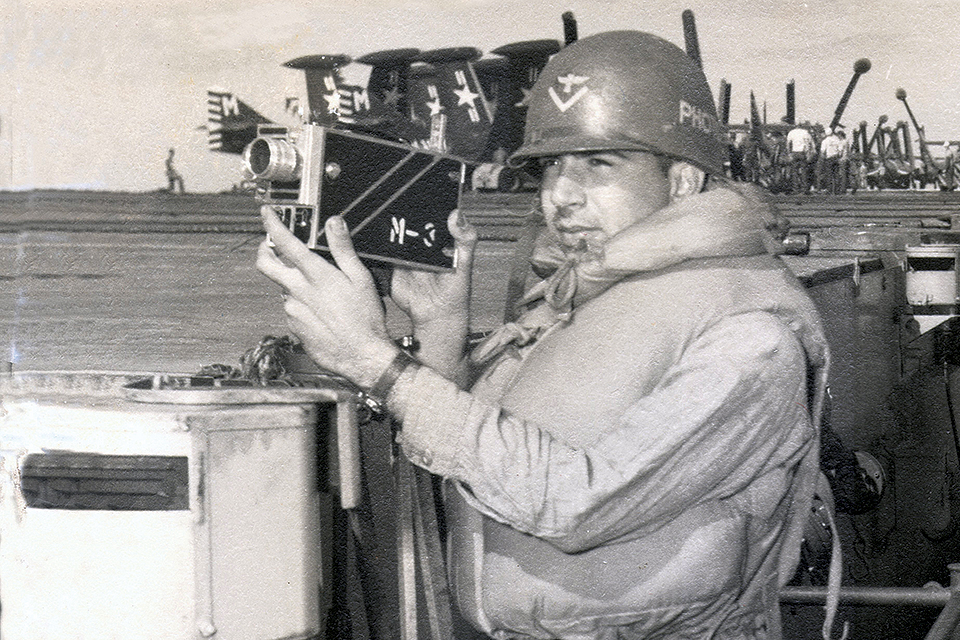 Aerial Photographer’s Mate Richard G. Wells holds a Kodak Cine Special movie camera at his station on Yorktown.