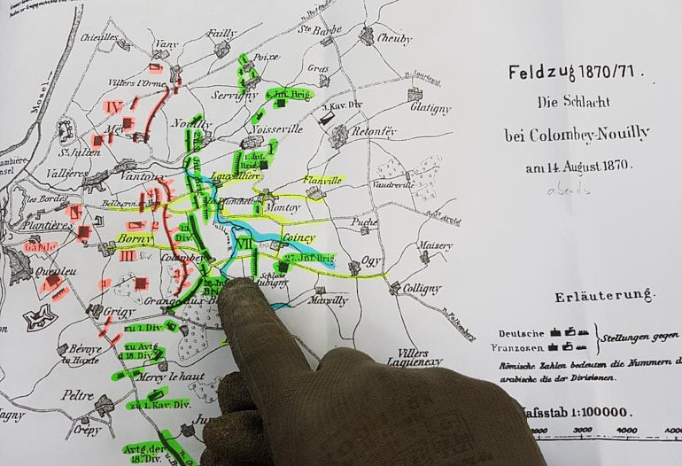A German War Graves Commission worker points out the battle site on a map. / German War Graves Commission photo
