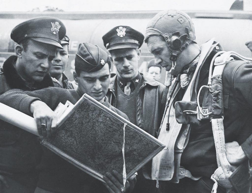 As a pilot stationed in England during the war, Stewart studies maps in the hands of a base intelligence officer before a mission. (Courtesy of the Film Stills Collection, L. Tom Perry Special Collections, Brigham Young University)