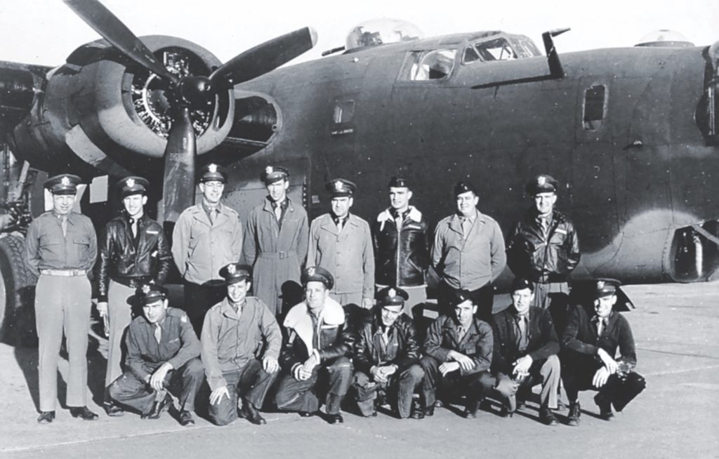 Stewart (back row, center) stands before a B-24 with officers of the unit he commanded, the 703rd Bombardment Squadron. (National Archives)