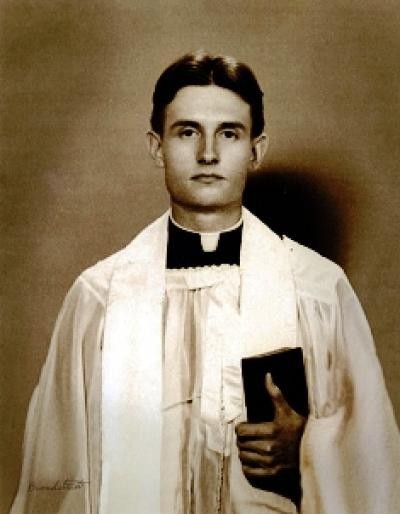Chaplain Capt. Emil J. Kapaun poses in his liturgical dress, bible in hand. (U.S. Army)