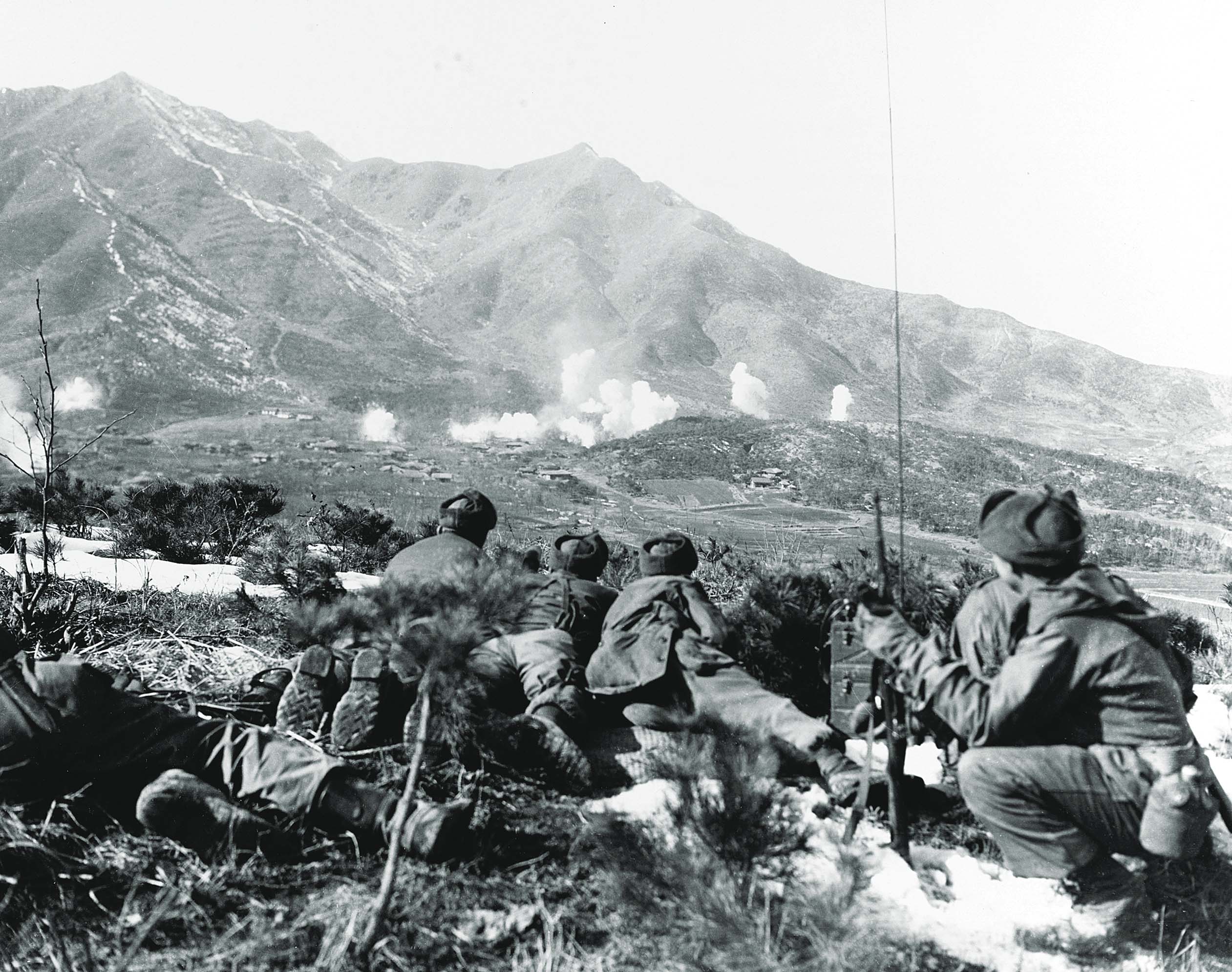 U.N. troops look on as artillery rains white phosphorous shells on enemy positions in the open. / Getty Images