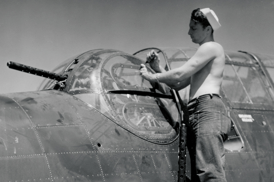 An aviation ordnancemen services a TBM-1C's .50-caliber gun turret. (National Archives)