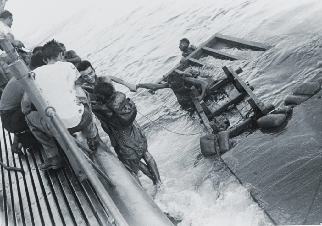 British and Australian POWs clamber aboard the USS Sealion after it and two other U.S. subs sank a pair of Japanese transports in September 1944. (National Archives)