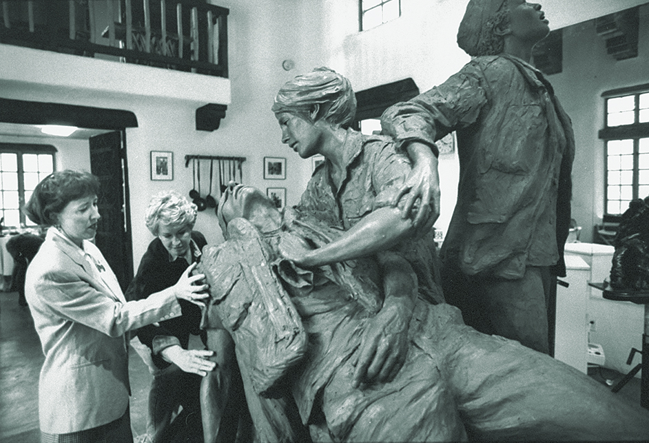 Vietnam veteran nurse/memorila advocate Diane Carlson Evans (L) standing nr. artist Glenna Goodacre as she works on an unfinished clay sculpture which features a nurse stroking the head of a fallen soldier as another woman scans the sky for evacuationas. sistance while a 3rd bows    (Photo by Dirck Halstead/Getty Images)