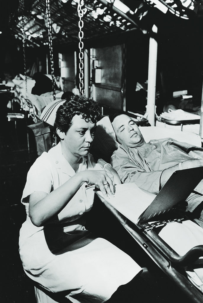 Photo of Lt. Cmdr. Dorothy Ryan, a Navy nurse, checks on a Marine aboard the Repose in 1966.