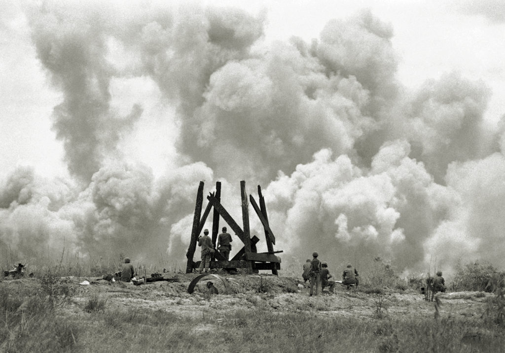 South Vietnamese soldiers watch clouds of smoke and dust rise from bombs dropped by U.S. B52's on May 19, 1972, less than two miles in front of their lines on route 13 in South Vietnam. The South Vietnamese forces are trying to link up with besieged government troops at An Loc, a provincial capital north of Saigon. (AP Photo/Nick Ut)