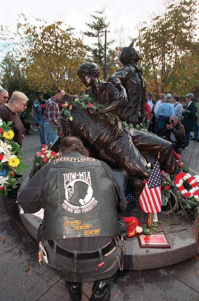 WASHINGTON, :  An unidentified visitor to the Vietnam Women's Memorial lays flowers in tribute to their service during Veteran's Day observances in Washington, DC 11 November. US President Bill Clinton hosted ceremonies at Arlington National Cemetery.    AFP PHOTO  Luke FRAZZA (Photo credit should read LUKE FRAZZA/AFP via Getty Images)