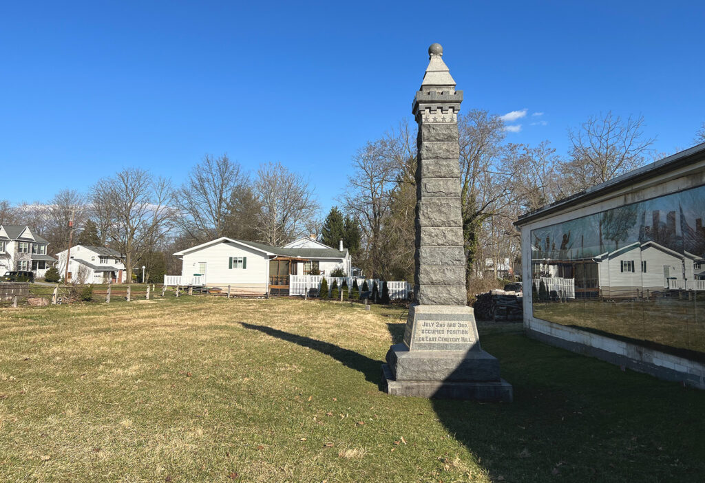 Modern image of 15th NY monument surrounded by houses