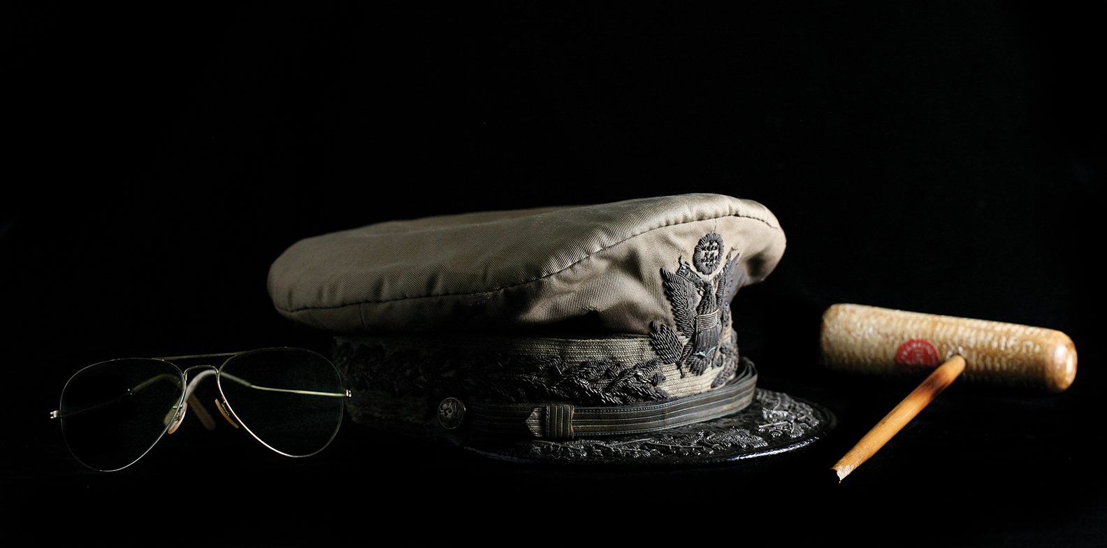 Photo of General Douglas MacArthur's crushed hat, aviator glasses and corncob pipe.