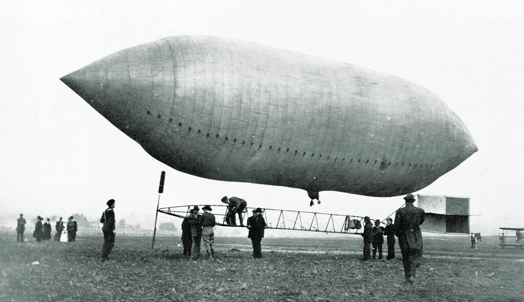 Photo of Daredevil and pilot Lincoln Beachey examines the airship owned by Thomas Scott Baldwin at the St. Louis Exposition of 1904.
