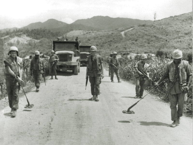 Photo of a Marine mine sweep team checks a road west of Ca Lu for enemy mines in 1968, a duty performed every morning.