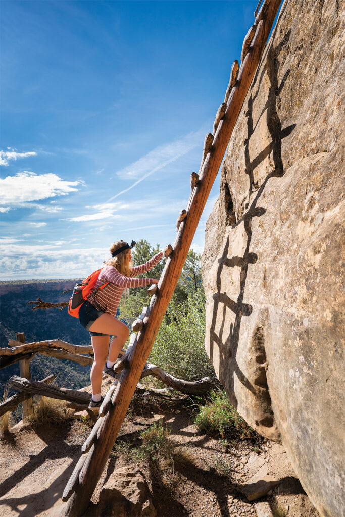 Photo of a female teenager climbs the 32 foot ladder to access Balcony House ruin, an Ancient Puebloan (Anasazi) cliff dwelling that was inhabited until the 13th century, Mesa Verde National Park, Colorado, USA