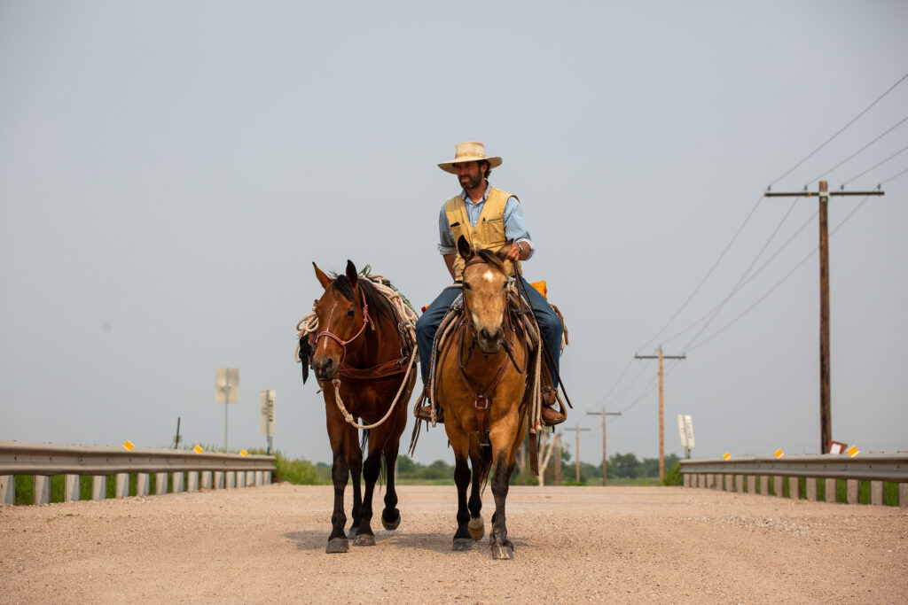 Grant riding horse with second horse walking beside