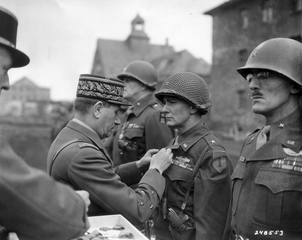 A French officer pins the Croix de Guerre on Brig. Gens. George A. Taylor (left) and Charles D. W. Canham on March 12, 1945. On Omaha Beach, Colonel Taylor rallied his 16th Infantry to break through and push 300 yards inland, declaring: “There are only two kinds of people who are staying on this beach: those who are dead and those who are about to die. Now let’s get the hell out of here!” Canham likewise motivated his 116th Infantry, telling one lieutenant hiding under mortar fire, “Get your ass out there and show some leadership!” Sgt. Bob Slaughter of the 116th was among those who responded, stating, “I was more afraid of Colonel Canham than I was of the Germans.” (National Archives)